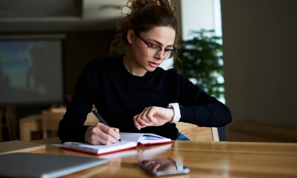 Women checking time while taking notes